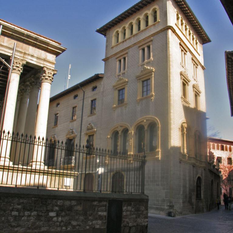 Ein historisches Gebäude mit klassischer Renaissance-Architektur und Säulenstrukturen unter blauem Himmel.