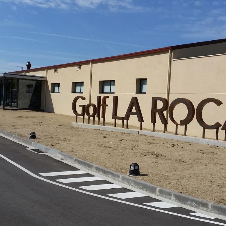Die Fassade eines Gebäudes mit der Aufschrift Golf La Roca an einer Straße.