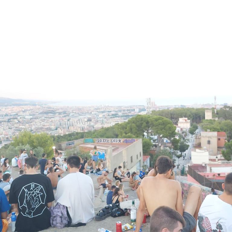 Panoramablick auf eine ausgedehnte Stadtkulisse mit vielen Menschen im Vordergrund.