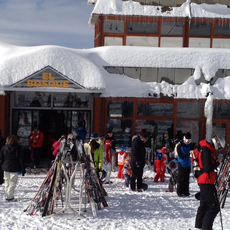 Ein belebter Ski-Shop mit Auslagen vor einem großen Gebäude im Schnee.